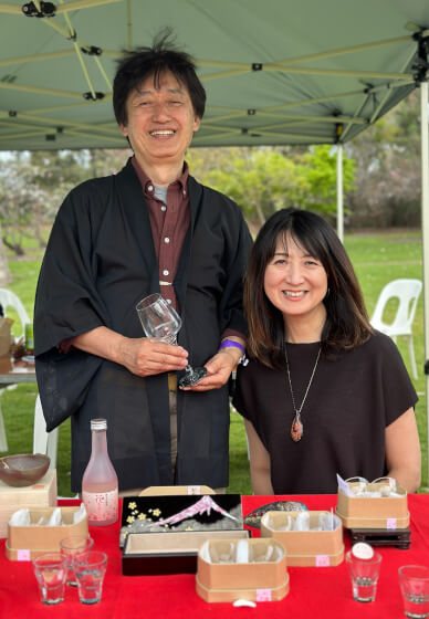 Akki in a haori and Hisae at an outdoor stall with raden pieces